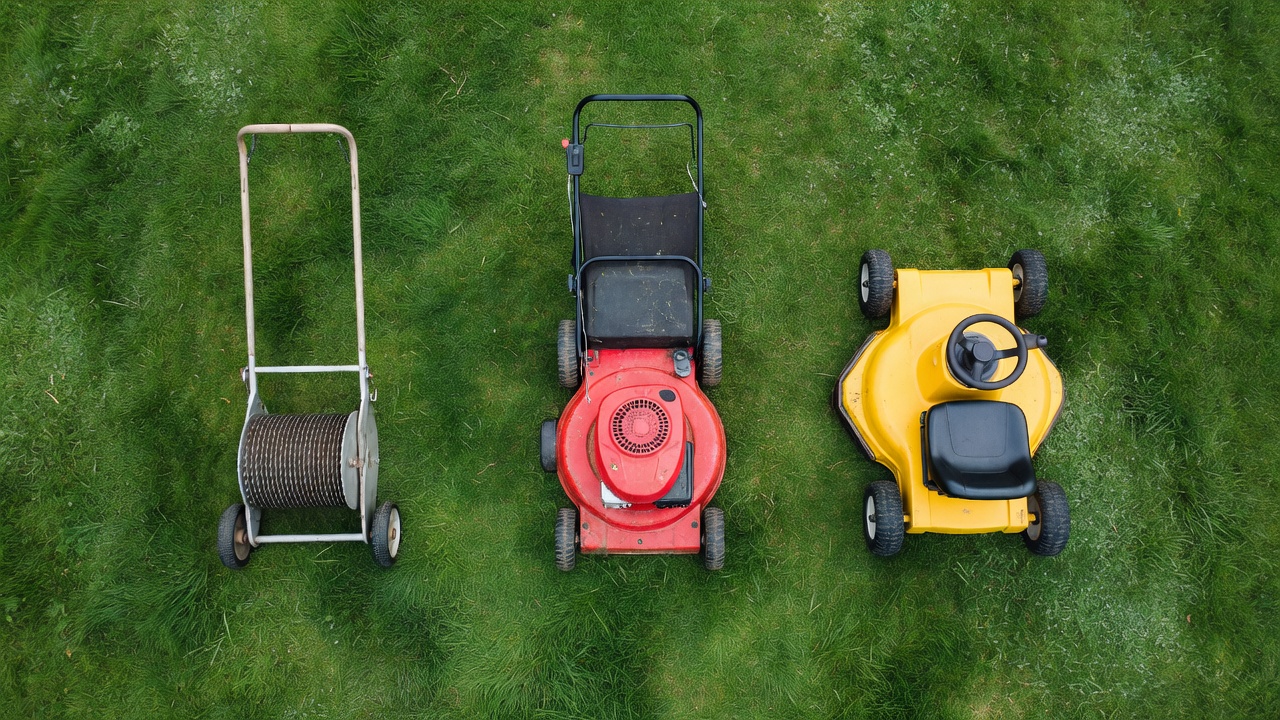 How Many Calories Do You Burn Mowing the Lawn? Three types of lawn mowers — push, self-propelled, and riding — arranged side by side on green grass