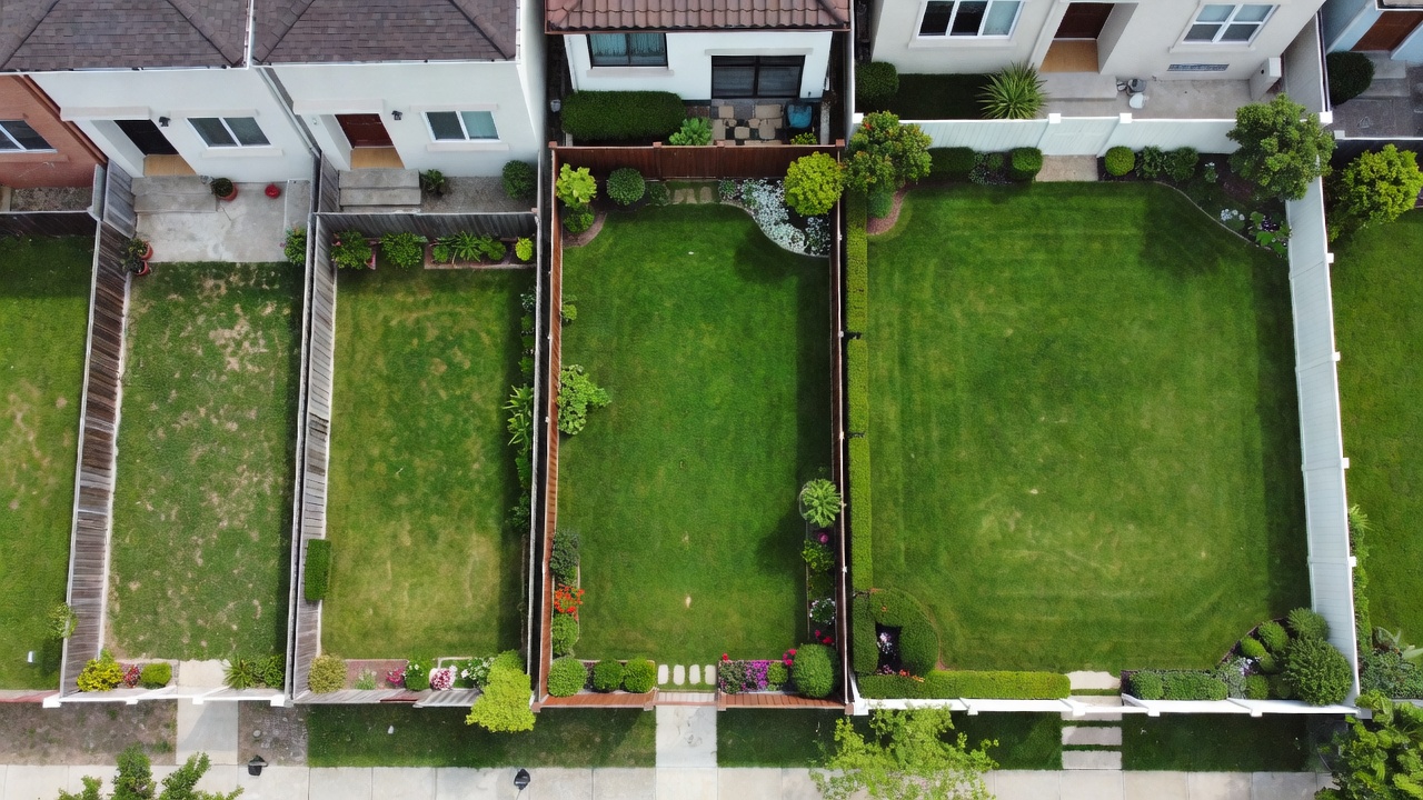 Aerial comparison of residential lawn sizes from small urban lot to large suburban property