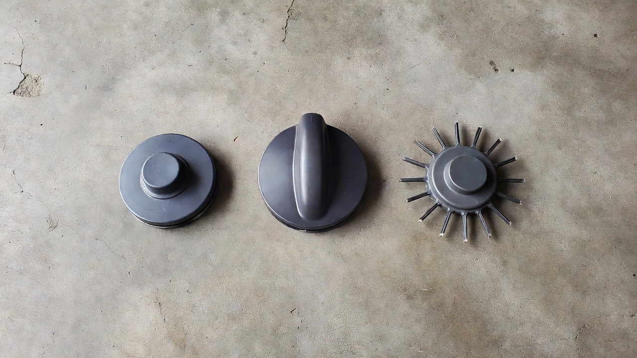 Three types of weed eater trimmer heads side by side — bump-feed, auto-feed, and fixed-line — on a concrete surface