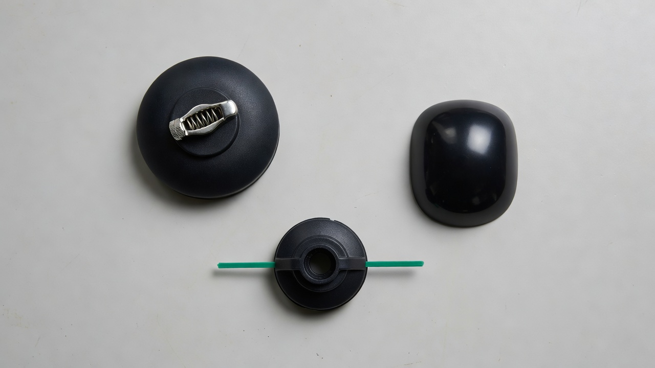 Three types of trimmer heads laid out on a workbench for comparison.
