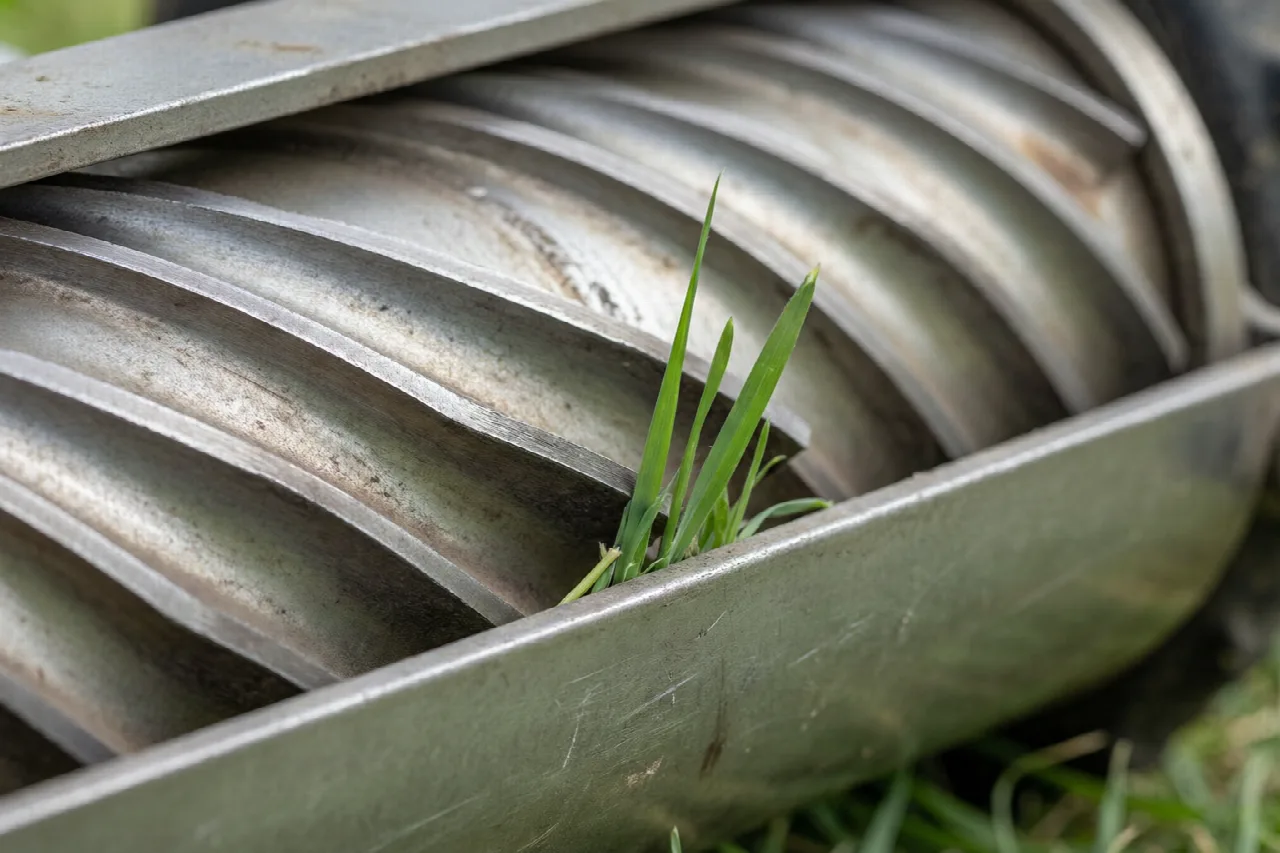 What Is Reel Mowing? Close-up of helical reel blades meeting a bedknife with grass between them